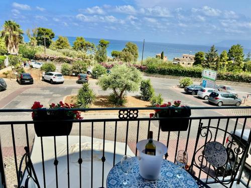 a table on a balcony with a view of a parking lot at Casa Yasmine in Santa Flavia