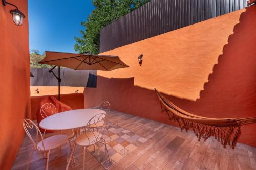 a patio with a table and chairs and an umbrella at Alte Com Amor in Alte