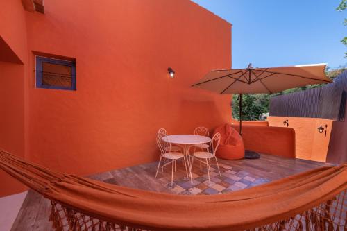 a hammock with a table and chairs and an umbrella at Alte Com Amor in Alte