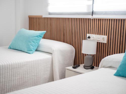 a hotel room with two beds and a blue pillow at 'Mi Esperanza' in Almuñécar