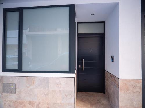 a hallway with a black door and a window at 'Mi Esperanza' in Almuñécar