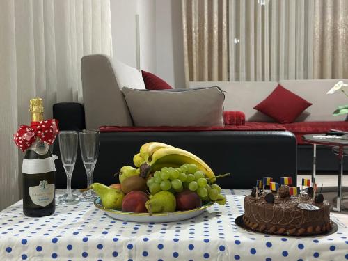 a table with a plate of fruit and a bottle of champagne at Queen Ekaterina II in Vlorë