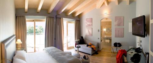 a living room with a couch and a tv at Parc Hotel Flora S in Riva del Garda