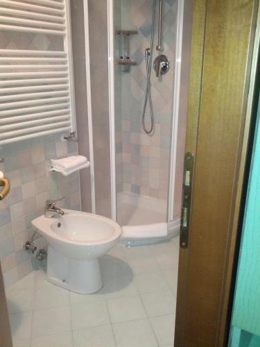 a bathroom with a shower and a toilet and a sink at Hotel Villa Tiziana in Venice-Lido