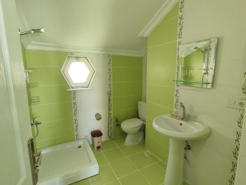 baño verde con lavabo y aseo en Penthouse, en Trabzon