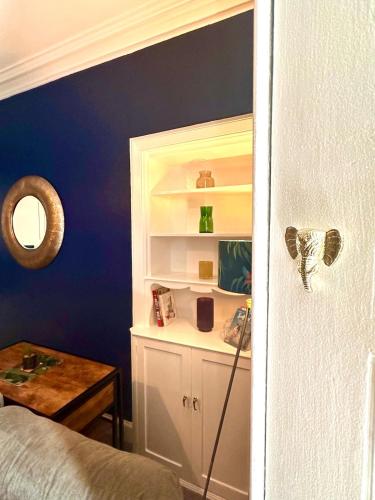a room with a bed and a blue wall at Small Cosy Flat in Helensburgh