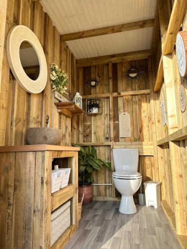 a wooden bathroom with a toilet and a sink at Deerstone Glamping-Weets Hill dome with Hot tub in Earby
