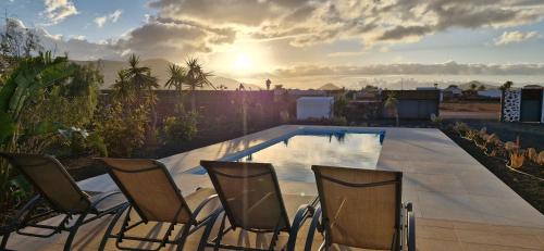 eine Gruppe von Stühlen neben einem Swimmingpool in der Unterkunft Villa Estrella de Blanca in La Oliva