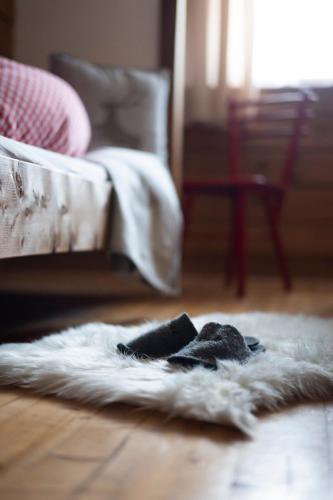 a white rug on the floor in front of a bed at BuchackerAlm -1,5h panoramic walk in Angerberg