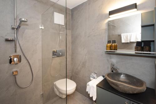 a bathroom with a sink and a toilet and a shower at Natural Deluxe Apartments Alpbach in Alpbach