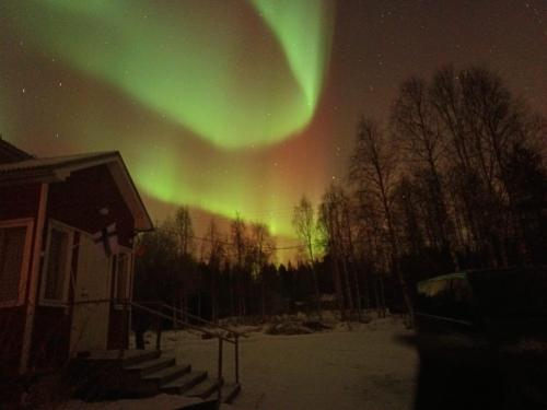 an aurora in the sky over a house at Chalet Pellonranta 2 in Mäkituoma
