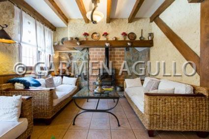 a living room with couches and a table at Posada el Campanario in Rascafría