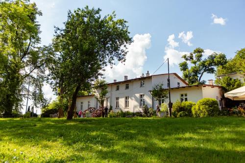 a white house with a tree in the yard at Domki Wierzchy in Wierzchy