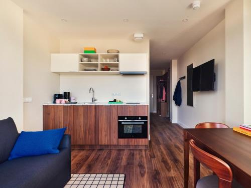 a living room with a couch and a kitchen at Numa The Hague Scheveningen in Scheveningen