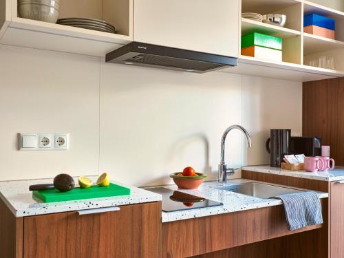 a kitchen with a sink and a counter top at Numa The Hague Scheveningen in Scheveningen