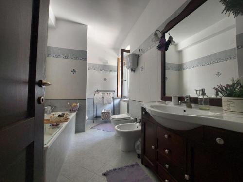 a bathroom with a toilet and a sink and a mirror at Civico 5 in Assisi