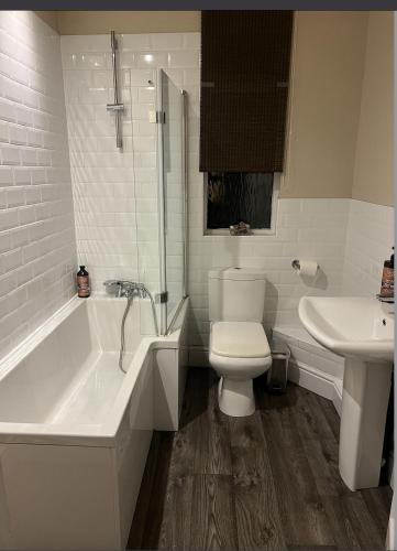 a bathroom with a tub and a toilet and a sink at My Big House Up North Grappenhall Warrington in Warrington