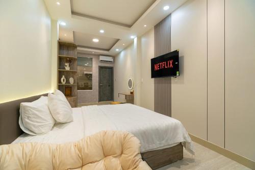 a bedroom with a bed and a tv on the wall at Hanhhome in Ho Chi Minh City