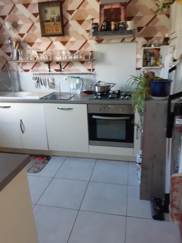 a kitchen with white cabinets and a stove top oven at Chambre lit double dans pavillon , chez Lilyanne in Tonnay-Charente