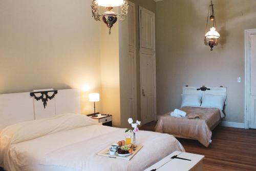 a bedroom with two beds and a table with a tray of food at La Irene - Casa de Campo y Golf in Azul