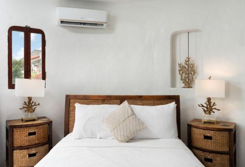 a bedroom with a white bed with two night stands at Coralita Apartments in Saint Michael