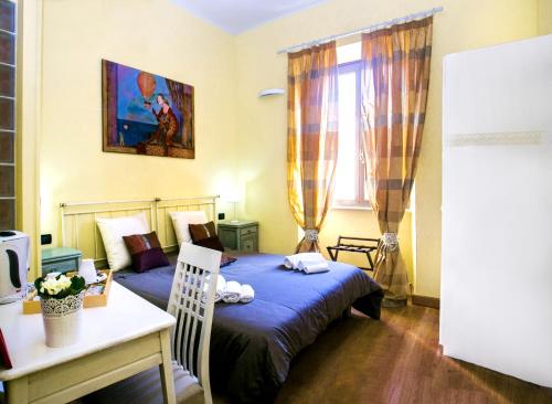 a bedroom with a bed, desk, chair, and lamp at Day by Day in Rome