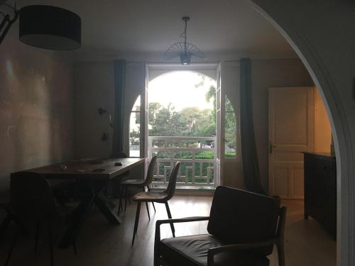 une salle à manger avec une table et une grande fenêtre dans l'établissement 25m Plage Benoit Grands Hôtels 3p Salon 2 Chambres 65m2, à La Baule