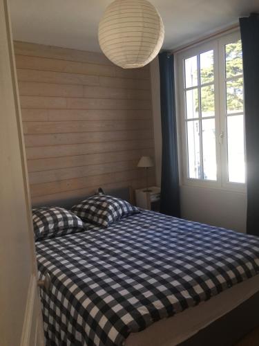 - une chambre avec un lit doté d'une couverture en damier bleu et blanc dans l'établissement 25m Plage Benoit Grands Hôtels 3p Salon 2 Chambres 65m2, à La Baule