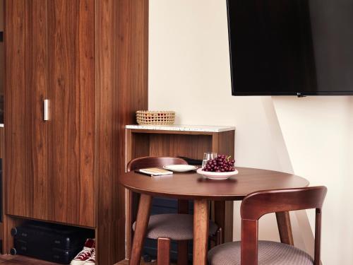 a small wooden table with two chairs and a television at Numa The Hague Scheveningen in Scheveningen