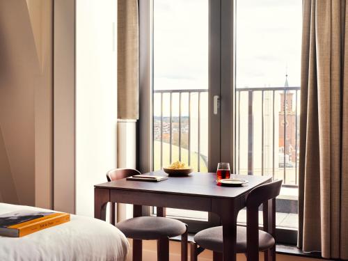 a room with a table and two chairs and a window at Numa The Hague Scheveningen in Scheveningen