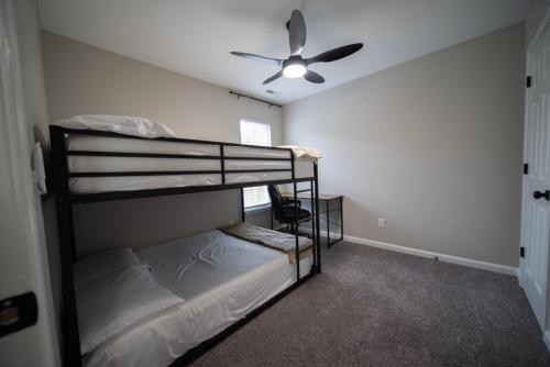 a bedroom with two bunk beds and a ceiling fan at Raleigh With Daylor in Raleigh