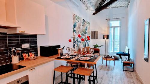 une cuisine avec une table et des chaises dans une pièce dans l'établissement Le Montmorency 56, déco rénové, proximité centre Climatisation, à Sète