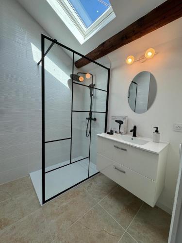 une salle de bain avec une douche en verre et un lavabo dans l'établissement Le Montmorency 56, déco rénové, proximité centre Climatisation, à Sète
