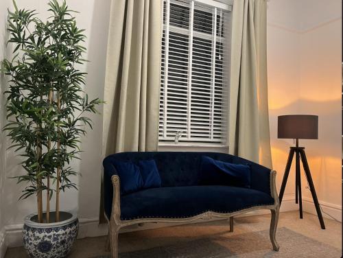 a blue couch in a living room with a window at My Big House Up North Grappenhall Warrington in Warrington