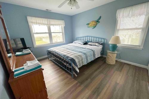 a bedroom with blue walls and a bed and a television at Beautiful beach and bayfront house in North Topsail Beach