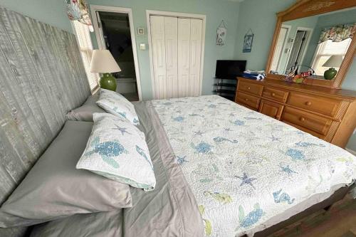 a bedroom with a bed and a dresser and a mirror at Beautiful beach and bayfront house in North Topsail Beach