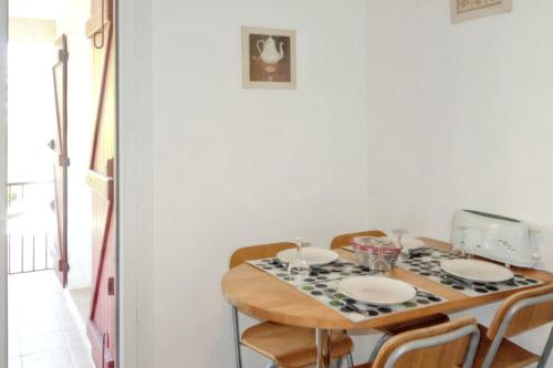 - une table à manger avec des chaises et une nappe dans l'établissement Appartement contemporain à Saint-Cyr-sur-Mer avec balcon., à Saint-Cyr-sur-Mer