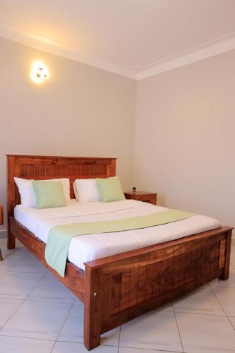 a bedroom with a large wooden bed in a room at The Residence Ug in Bulindo