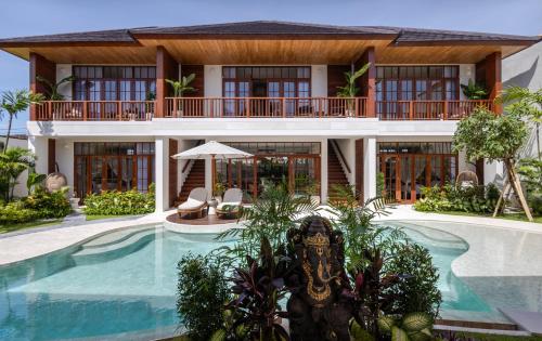 a house with a swimming pool in front of it at Plawa Laguna Bali in Canggu