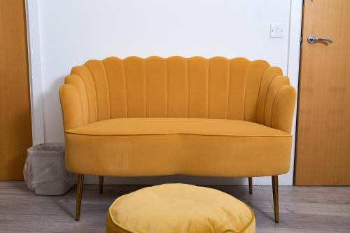 a yellow chair with a yellow stool in a room at Snooze Luxe House in Dallington