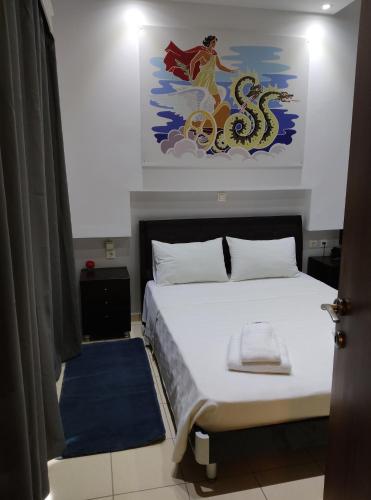 a bedroom with a bed with a painting on the wall at Anemi Leros Apartments 2 in Panteli