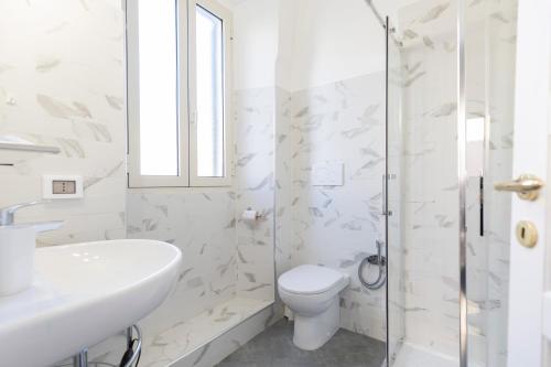 a white bathroom with a toilet and a sink at Residenza Portoferraio in Portoferraio