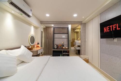 a hotel room with a white bed and a bathroom at Hanhhome in Ho Chi Minh City
