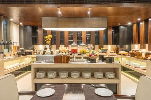 a kitchen with a table with plates on it at Country Inn & Suites by Radisson, Bhiwadi in Bhiwadi