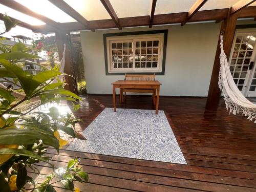 a porch with a hammock and a wooden floor at Casa aconchegante em Garopaba in Garopaba