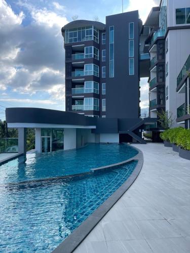 a swimming pool in front of a building at 2BR 4Beds Luxury Condo Pool & Fitness in Phuket