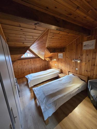 - une chambre avec 2 lits dans une cabane en bois dans l'établissement Chalet le Feufy, à Morzine