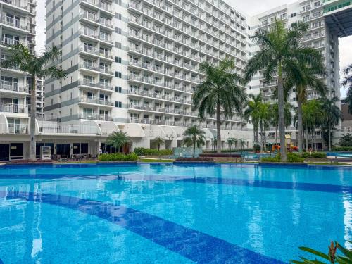 a large swimming pool in front of a large building at Shell Residences Pasay 1BR Walk to MOA Newly Renovated! in Manila