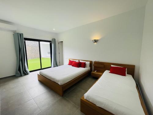 Dos camas en una habitación con ventana. en Villa Maria, en Playa Blanca