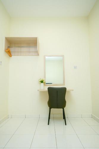 a chair sitting in a room with a white wall at Arista Guest House in Pasir Bogak